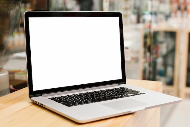 Laptop on wooden surface mockup