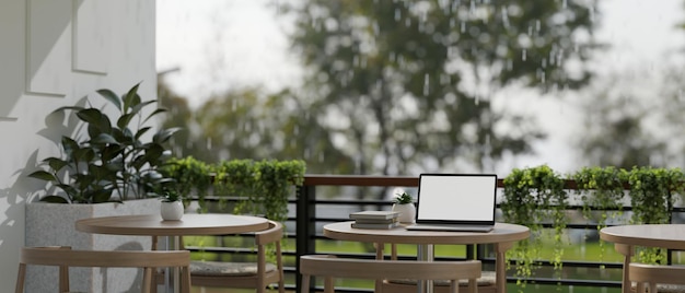 A laptop on a wooden table on a balcony on a rainy day cafe coffee shop relaxation area outdoor