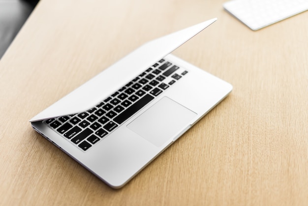 Laptop on wooden table and blurred background