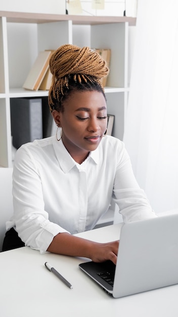 Foto lavoro al portatile lavoro a distanza donna concentrata che scrive