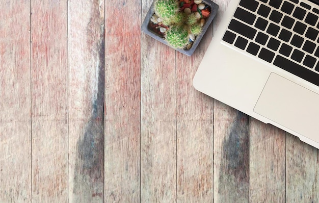 Laptopcomputer en cactus op houten tafel achtergrond