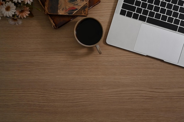 Laptopcomputer kopje koffie en vintage boek op houten tafel