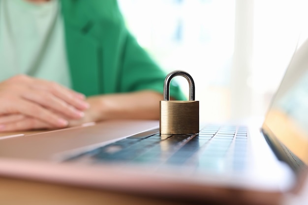 Laptopcomputer met hangslot op bureau en zakenvrouw of manager in achtergrondgegevens