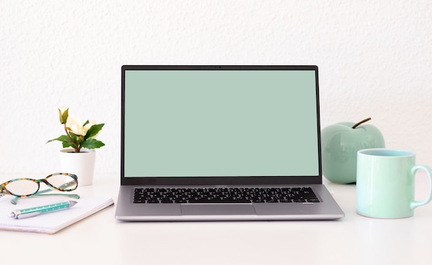 Laptopcomputer met leeg groen scherm op witte achtergrond. Ruimte kopiëren. Zakelijk, studeren, werken op afstand, niemand