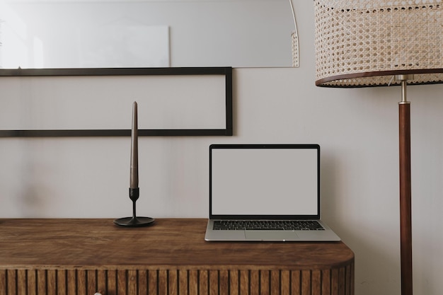 Laptopcomputer op houten console met kaars vloerlamp Esthetisch elegant gestileerd huis woonkamer interieur Online winkel blog sociale media winkel branding sjabloon met lege kopie ruimte