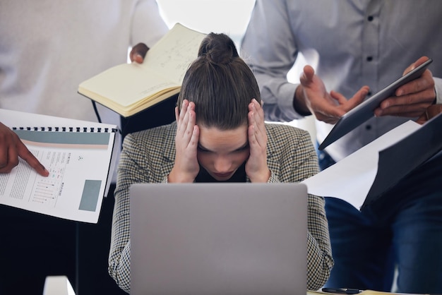 Foto laptophoofdpijn en multitasken met een zakenvrouw en veeleisende collega's die op kantoor werken stressangst en deadlinedruk met een overweldigde vrouwelijke werknemer aan het werk op een computer