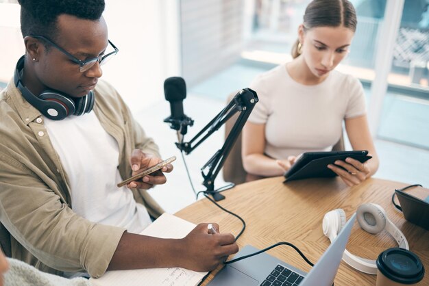 Laptoppodcastteam en mensen op kantoor voor het maken van livestreaming van inhoud en talkshow samenwerkingsstudio en man en vrouw met microfooncomputer en technologie voor radio-uitzending