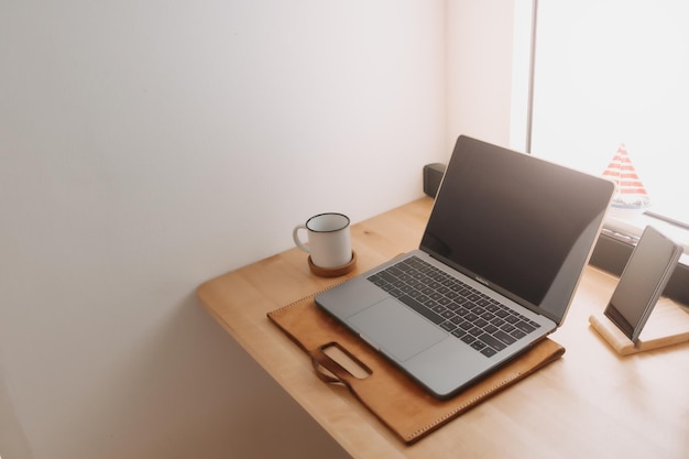 Laptopwerkruimte op houten bureau bij de ramen