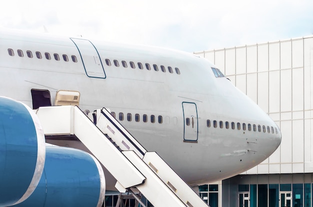 Grande aereo prima della partenza per un volo nel parcheggio dell'aeroporto sullo sfondo di un terminal passeggeri.