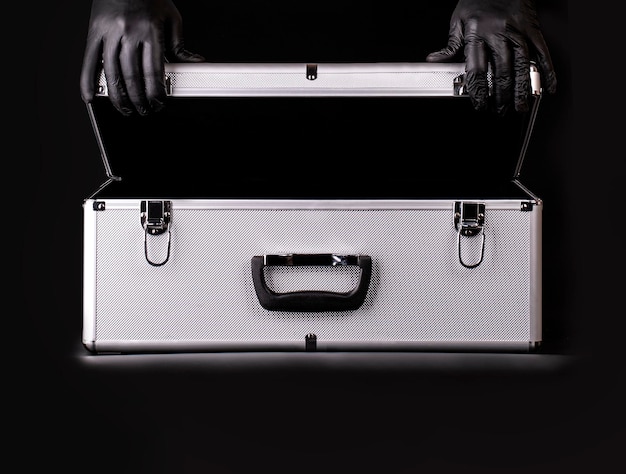 Photo the large aluminum suitcase and hands black safety gloves