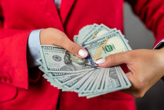 Large amount of money in a purse holding a beautiful woman with her feminine hands in front