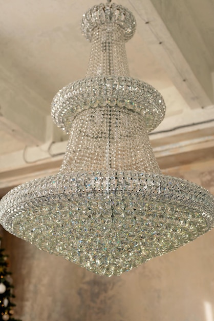 Large antique crystal chandelier in loft style interior. Soft side-by-side focus.