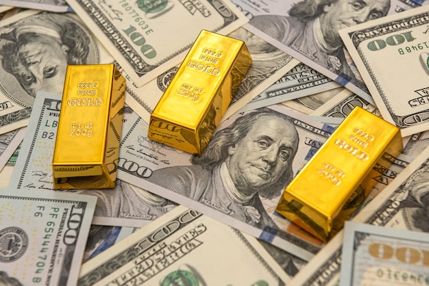 Золотые слитки крупных банков на долларовых купюрах. концепция экономии