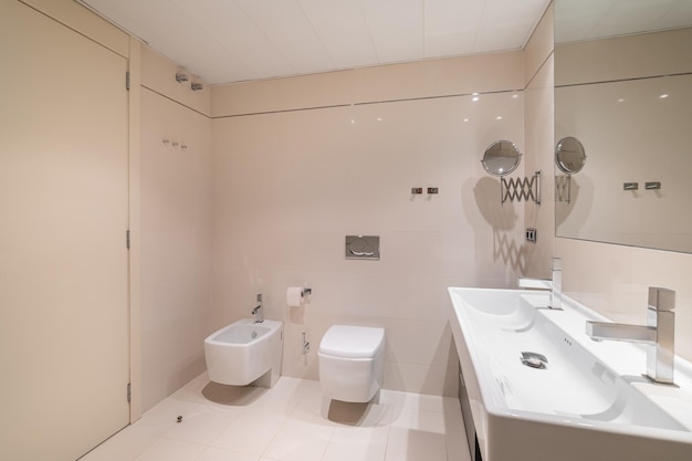 Large bathroom decorated with beige tiles square full length mirror and rectangular sink with two