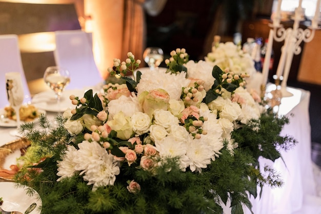 A large beautiful bouquet of flowers on the table of the newlyweds at the wedding