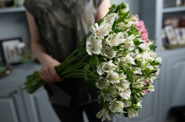 女性の手で混合花の大きな美しい花束