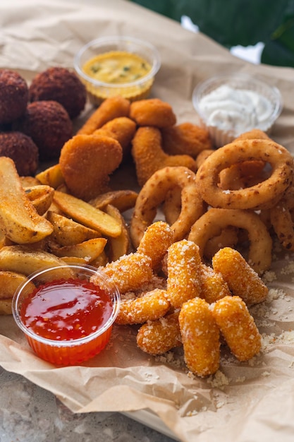 Foto grande set da birra di crocchette di pollo con patatine fritte e anelli di cipolla