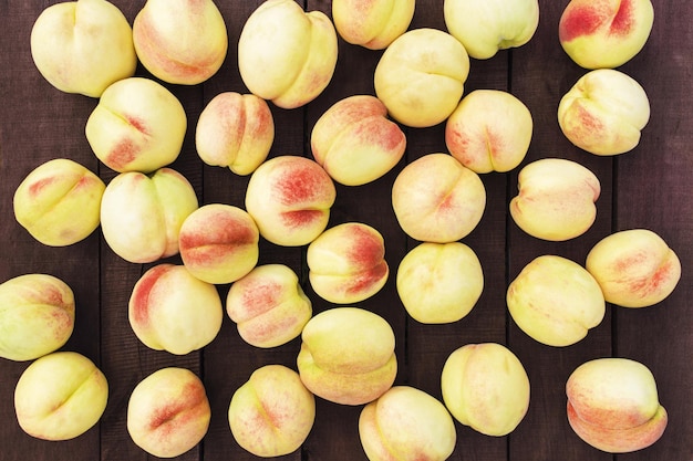 Photo large and big juicy peaches on brown wooden table background with boards