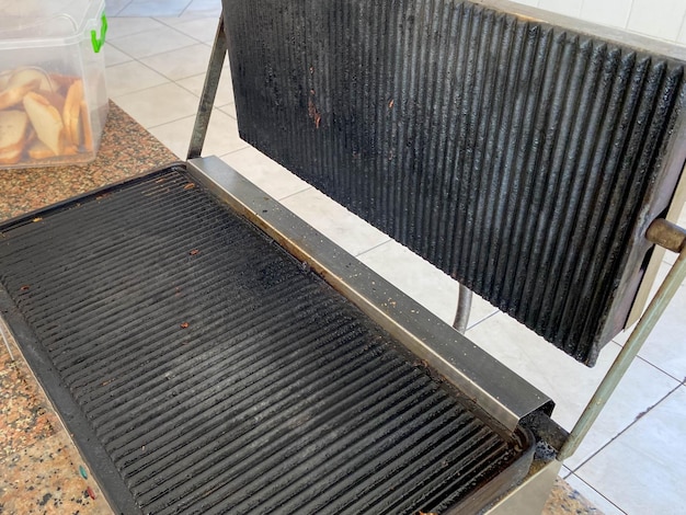 Large black iron grill for frying meat food in the kitchen in the cafeteria in the cafeteria
