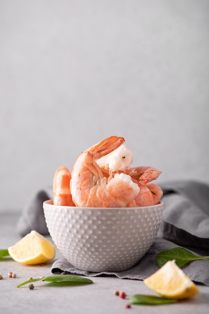 Large boiled shrimp in shell in a gray bowl, close-up