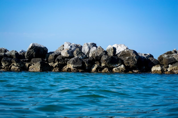 Large boulders in the sea against the blue sky