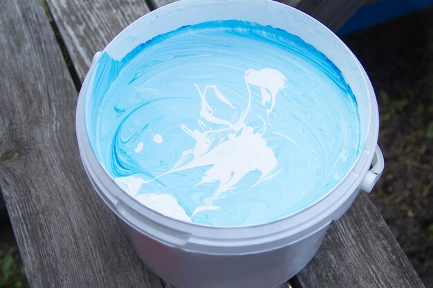 The large bucket is diluted with white and blue paint