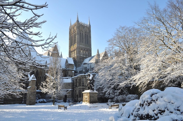 a large building with a statue in front of it covered in snow