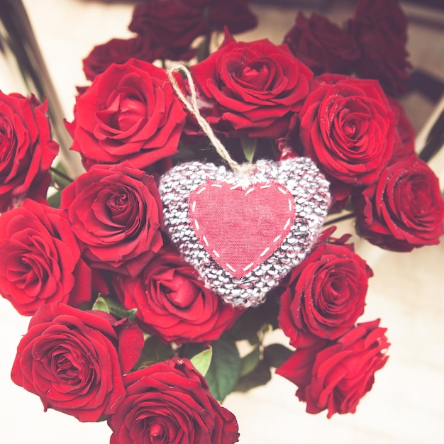 Фото Большой букет красных роз и стильное вязаное сердце стильное пространство концепции любви для текста