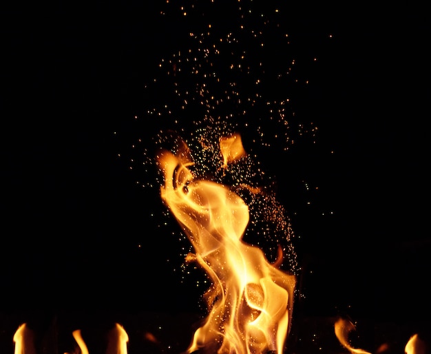 Large burning bonfire with flame and orange sparks