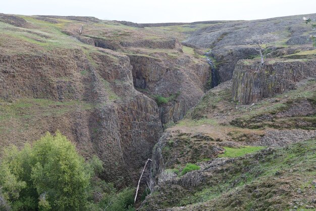 Photo a large canyon with a waterfall in the middle of it