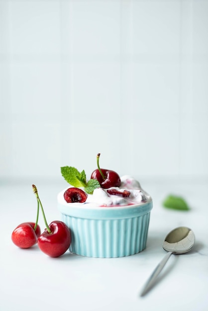 Фото Большие вишни с греческим йогуртом и мятой в голубой миске