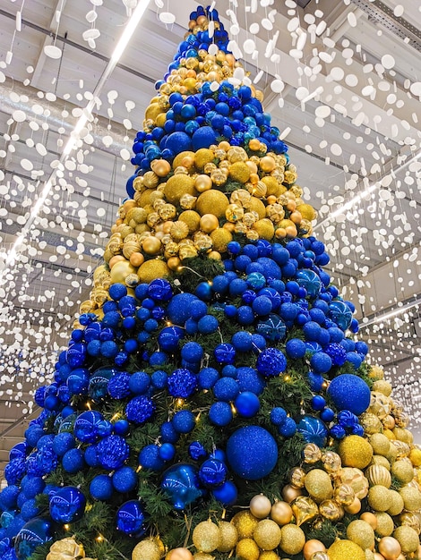 A large Christmas tree with yellow and blue balls