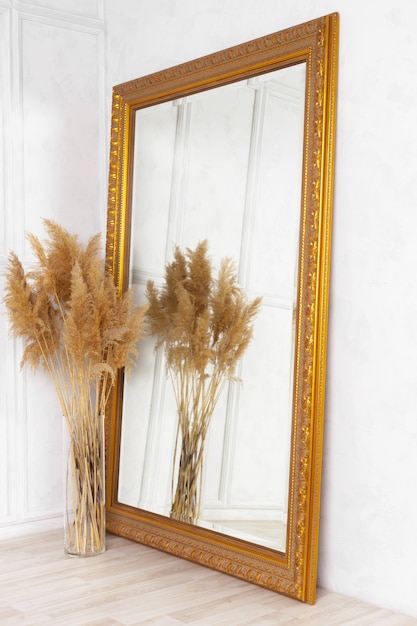 Large classic mirror with golden wooden frame side view, home decor