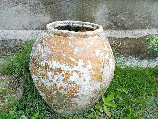 A large clay pot is sitting in the grass.