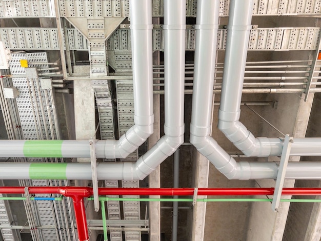Foto il grande tubo complesso di vari sistemi è appeso al soffitto nella stazione ferroviaria urbana nella vista frontale in costruzione per lo spazio di copia