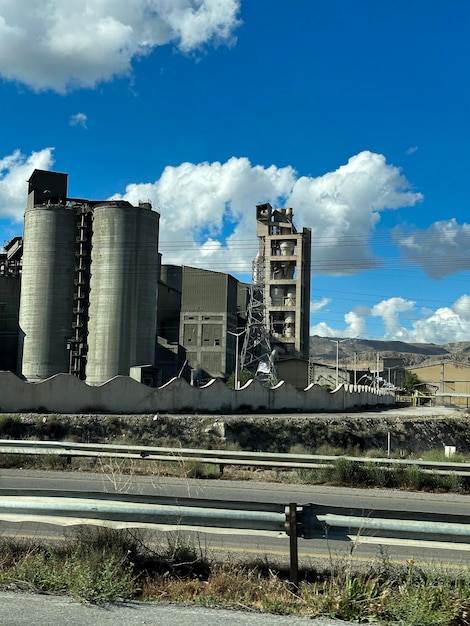 A large concrete factory is surrounded by a blue sky.