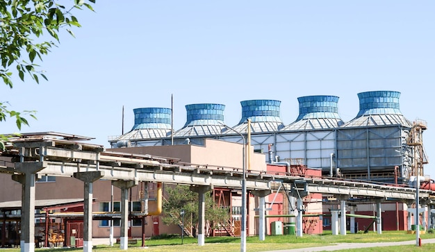 A large concrete pipeline trestle with pipes and wires for electricity at an oil refinery