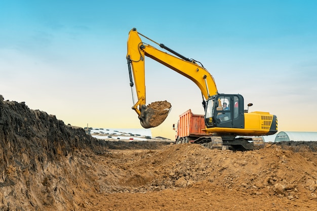 Photo a large construction excavator of yellow color on the construction site in a quarry for quarrying. industrial image.