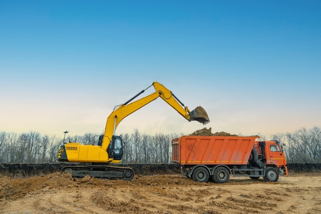 A large construction excavator of yellow color on the construction site in a quarry for quarrying. Industrial image.