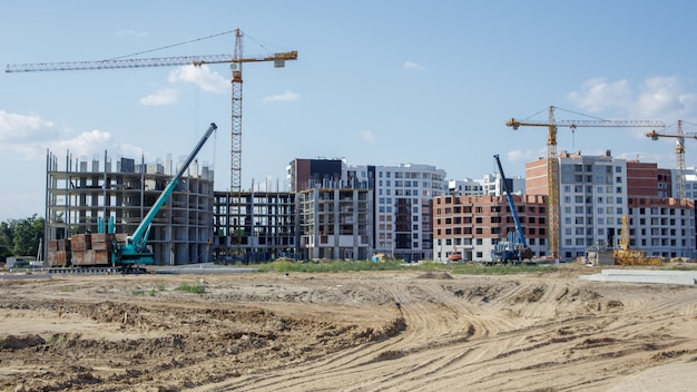 Large construction site. The process of capital construction of a high-rise residential complex. Modern residential building. Concrete building, construction, industrial site.