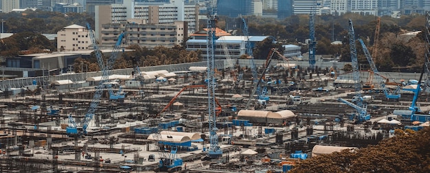 Фото Большая строительная площадка с тяжелой строительной техникой в мегаполисе