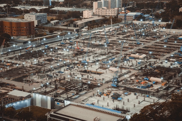 Large construction site with heavy construction machinery in metropolis