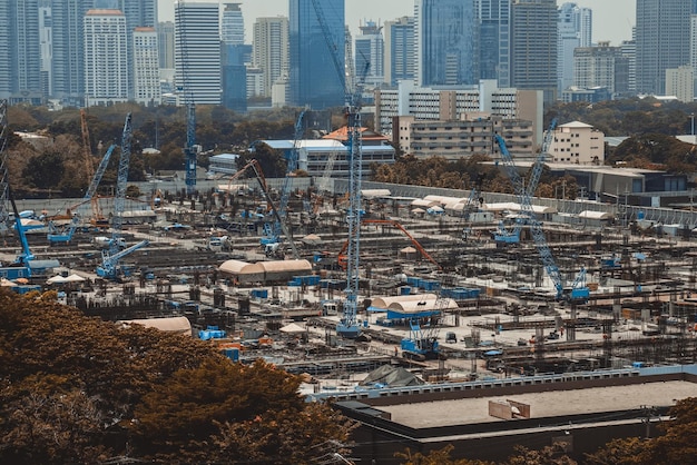 Large construction site with heavy construction machinery in metropolis