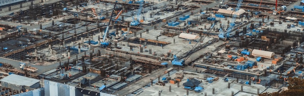 Large construction site with heavy construction machinery in metropolis