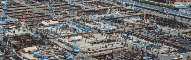 Large construction site with heavy construction machinery in metropolis