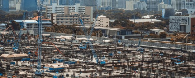 Large construction site with heavy construction machinery in metropolis