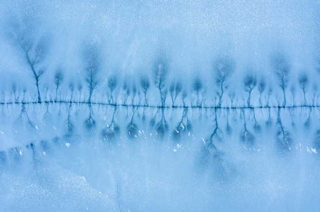 Grande crepa nella superficie ghiacciata di un lago ghiacciato. vista aerea dall'alto.