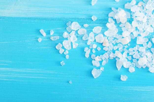 Large crystals of rock salt on a blue wooden  