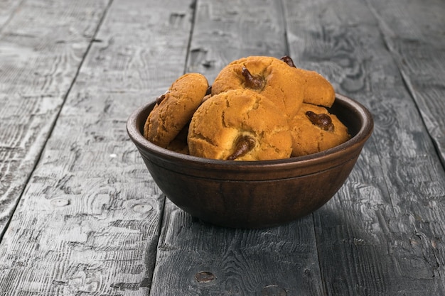 Una grande ciotola profonda con biscotti di farina d'avena freschi su un tavolo rustico