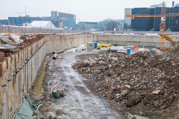 A large deep foundation pit is digging excavators Building a house in the city